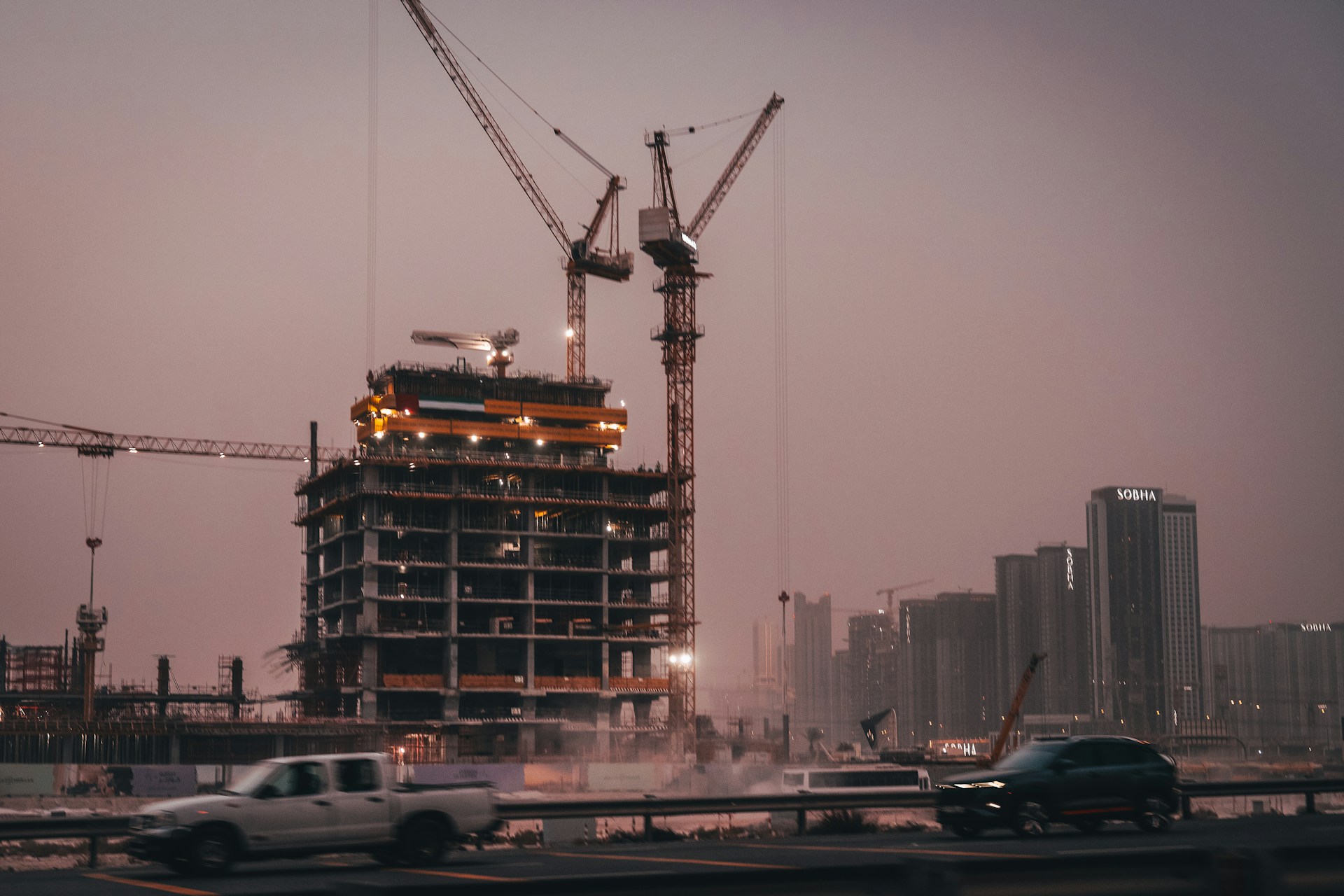 Construction site with cranes and unfinished building.