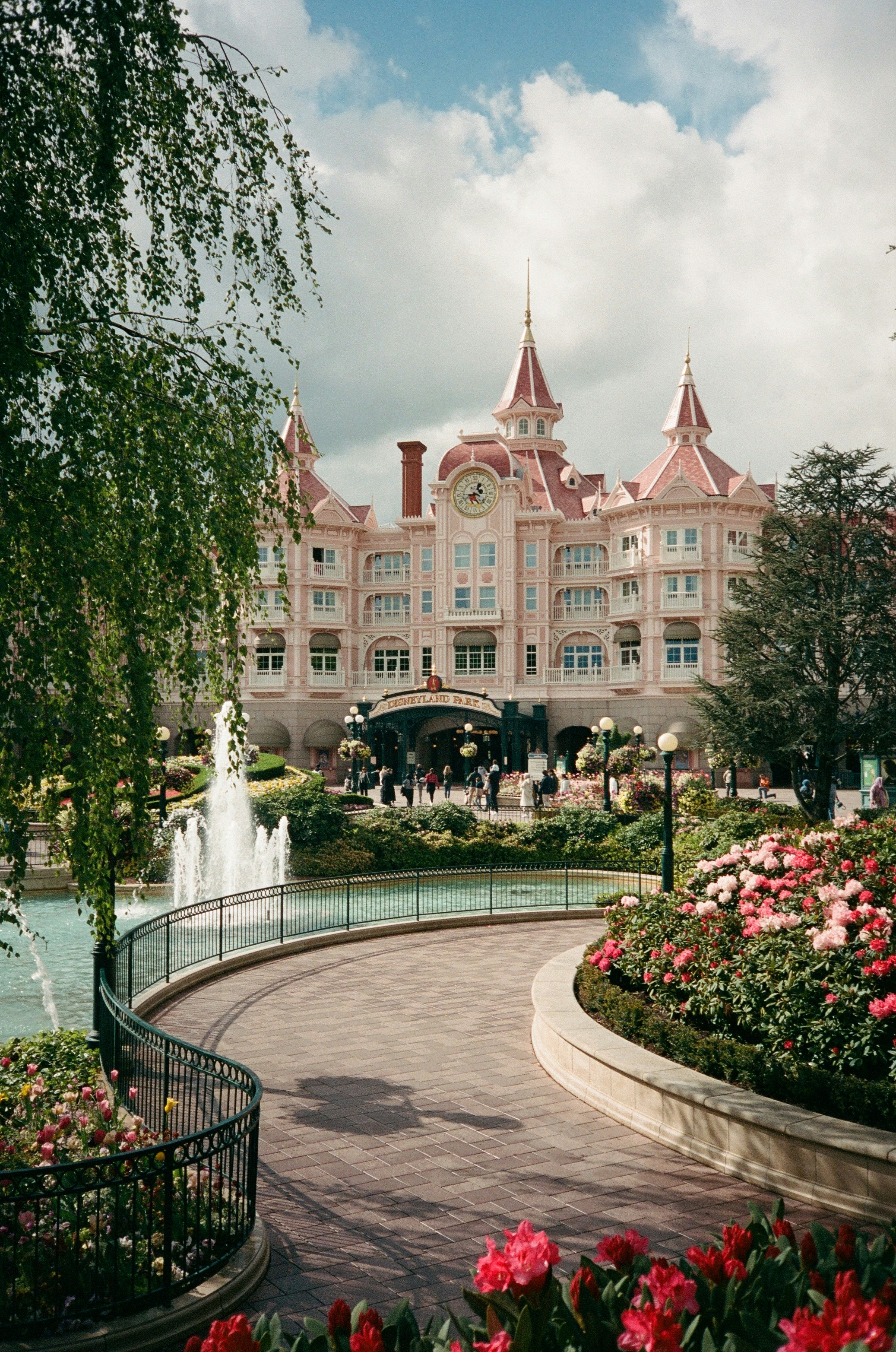 Grande hotel rosa com fonte e jardins florais