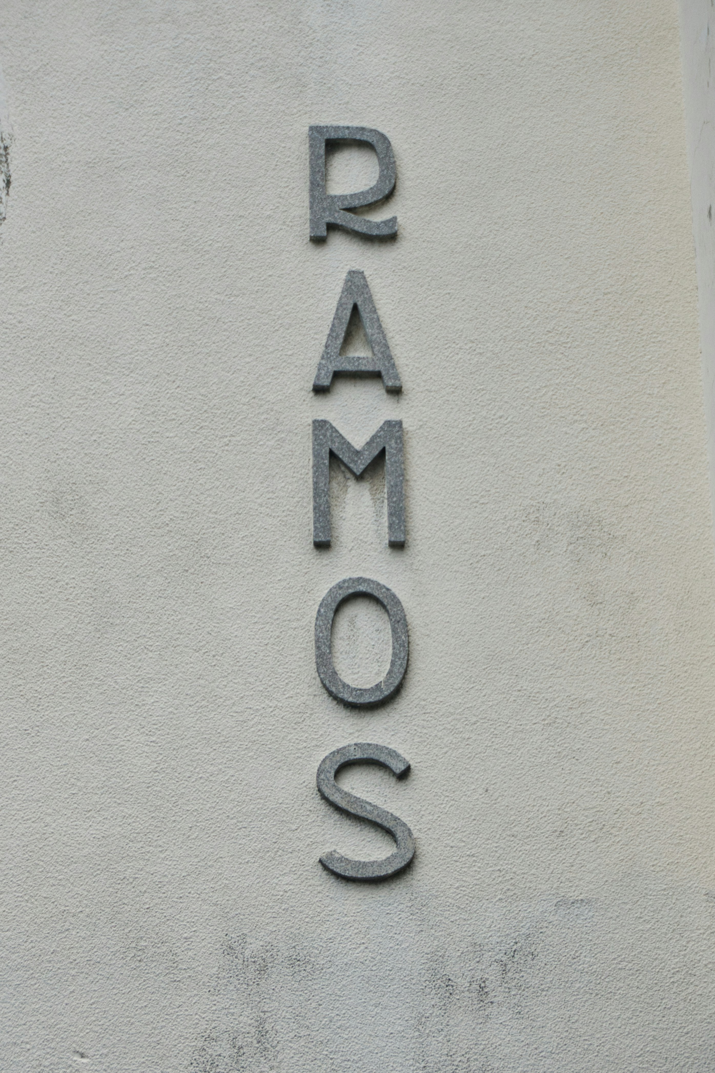 La palabra ramos deletreada verticalmente en una pared texturizada.