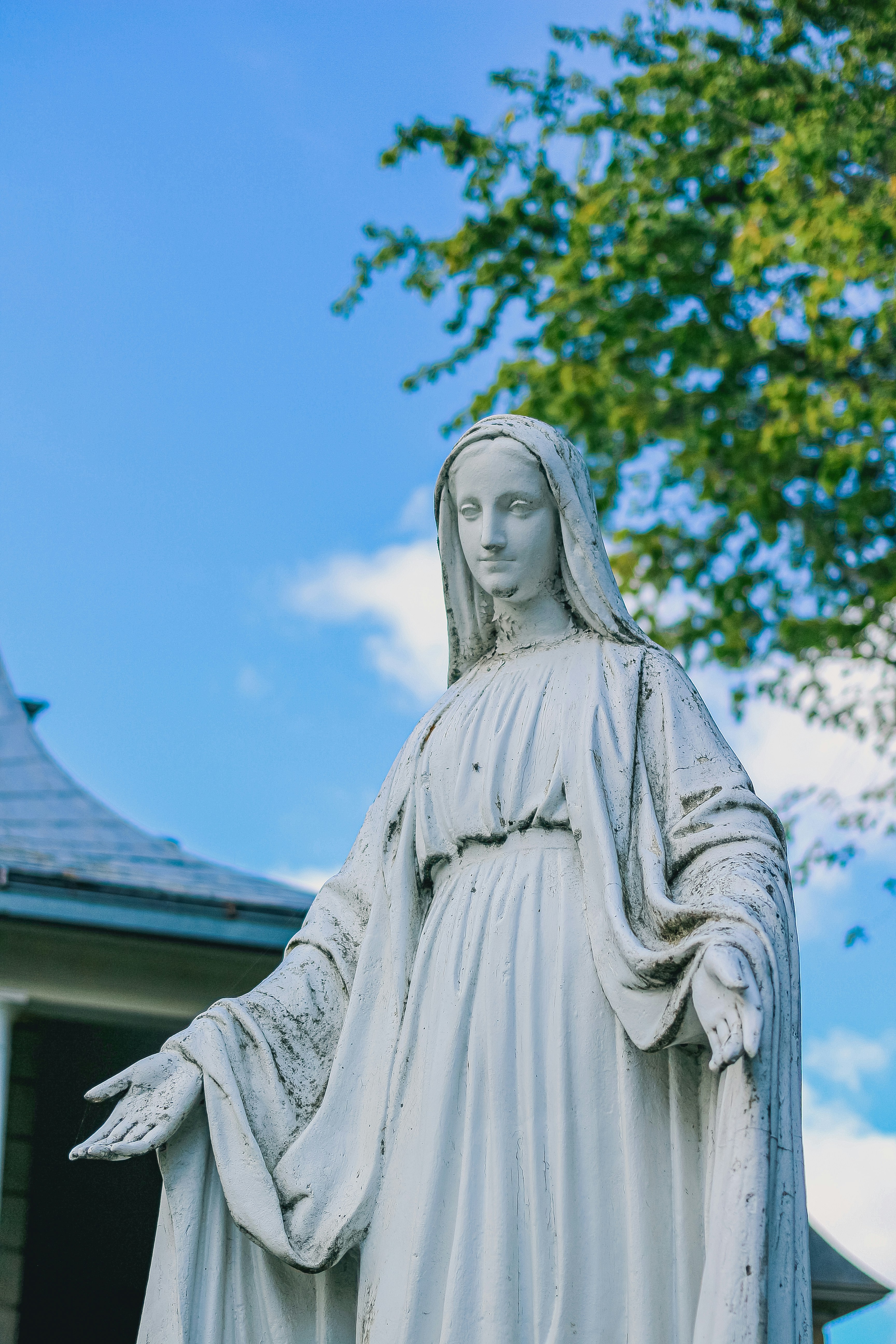 White statue of mary with outstretched arms