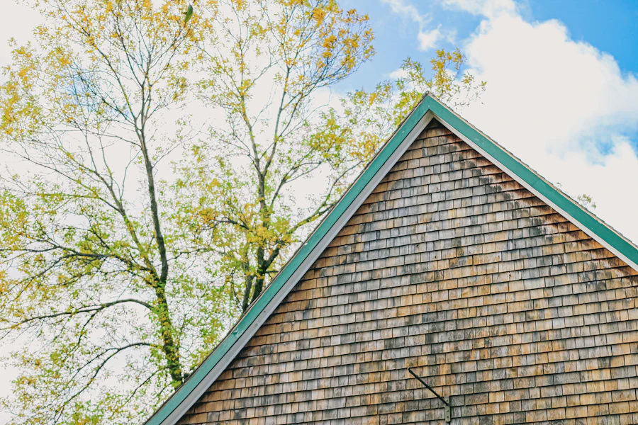 A cedar shingle gable with green trim among trees