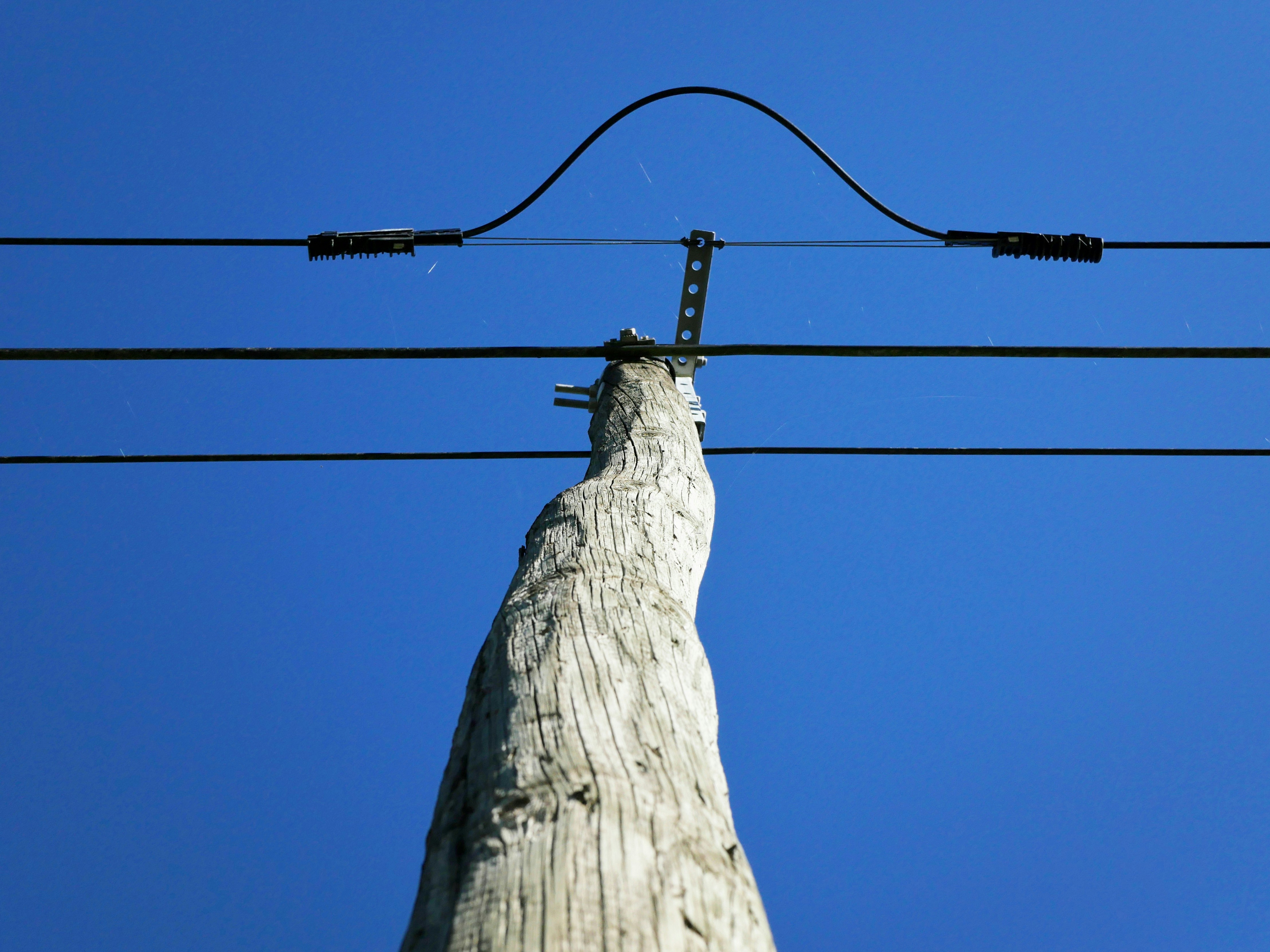 Wooden utility pole against a clear blue sky