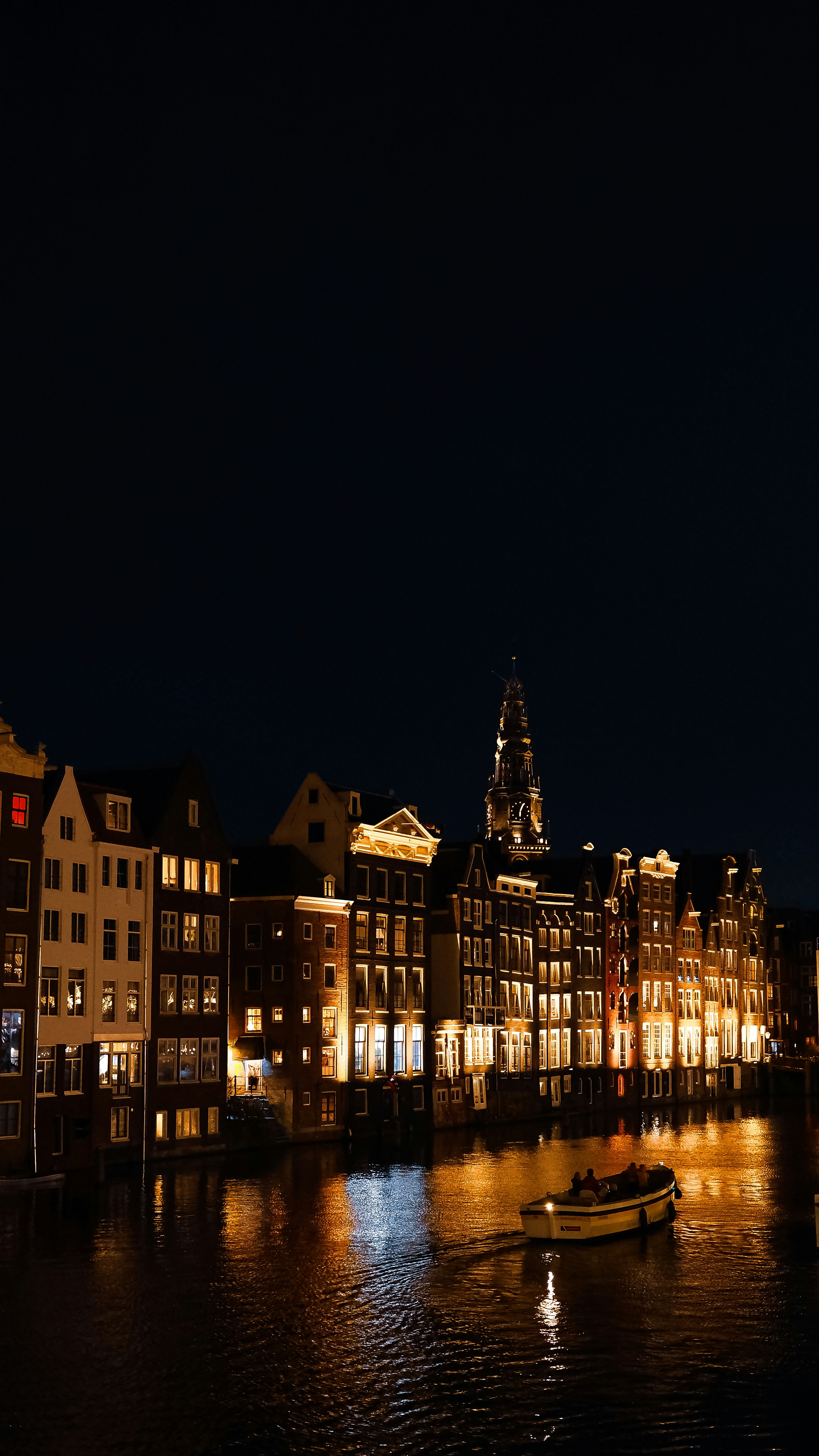 운하를 따라 밤에 조명이 켜진 도시 건물.