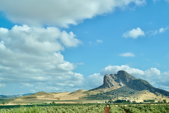 Rocky mountain peak under a cloudy blue sky.