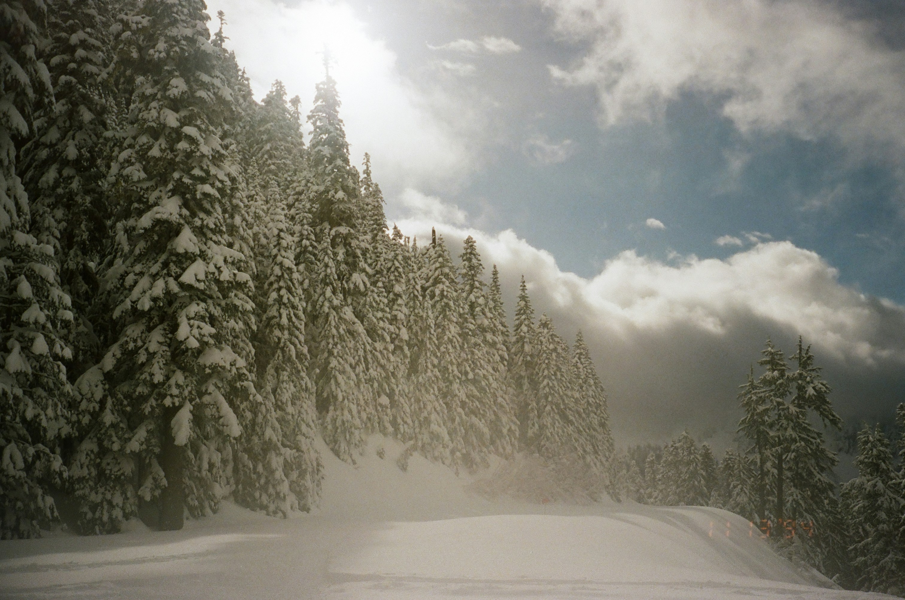 太陽の雲が照らされた雪道