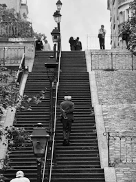 Man walks up grand staircase with people above
