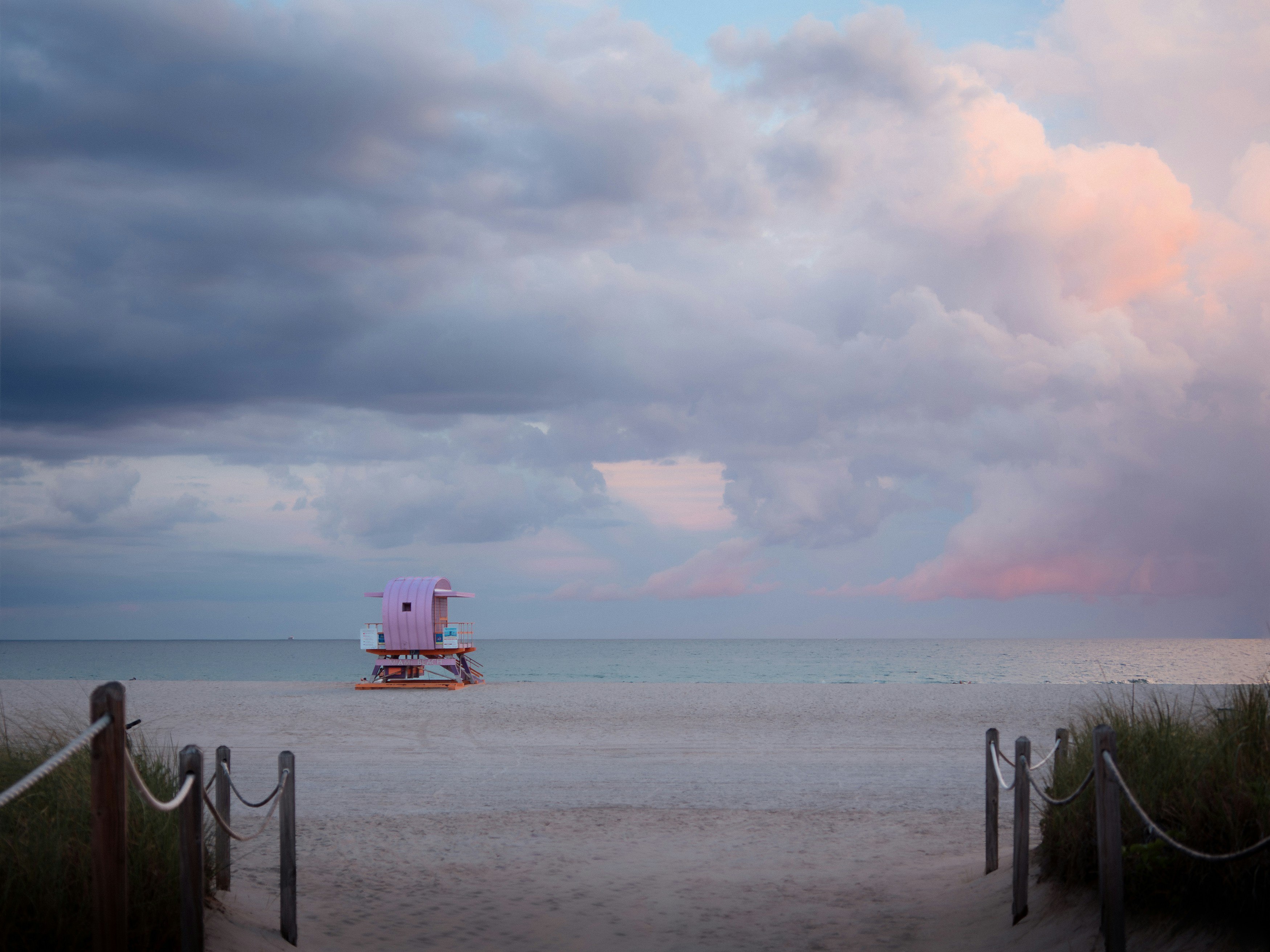 Pink lifeguard tower on a beach at sunset