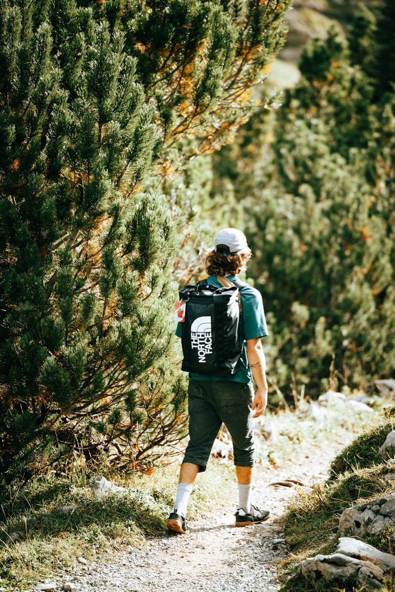 Wanderin mit Rucksack auf einem alpinen Pfad