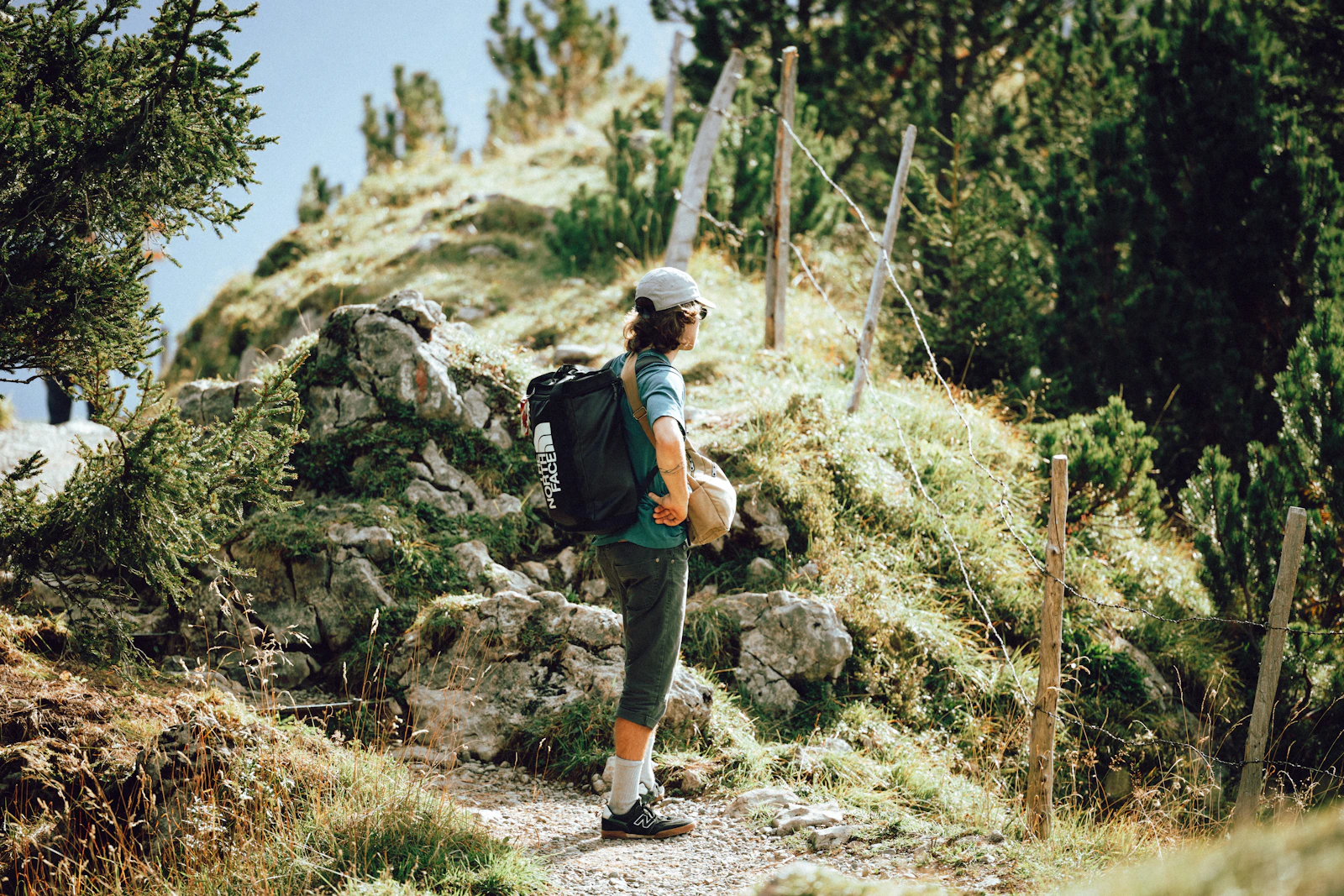 Mountain trail crossing changing terrain beside alpine water