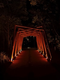 Осветена дървена арка, сияеща в нощта и създаваща приветлива атмосфера с Hedgie Wilder