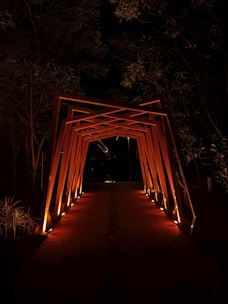 Осветена дървена арка, сияеща в нощта и създаваща приветлива атмосфера с Hedgie Wilder