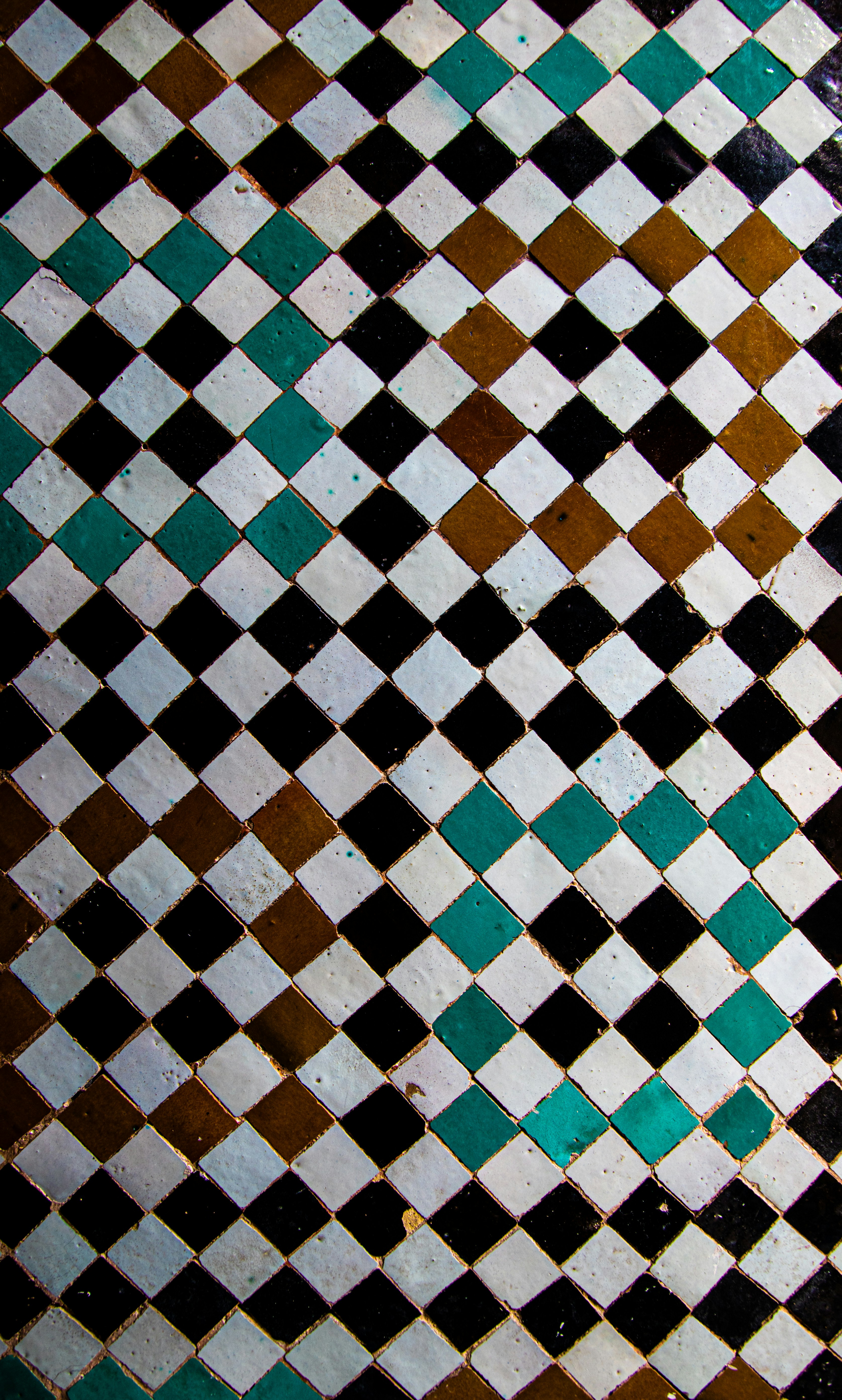 Diamond pattern mosaic with white, black, brown, and teal tiles.