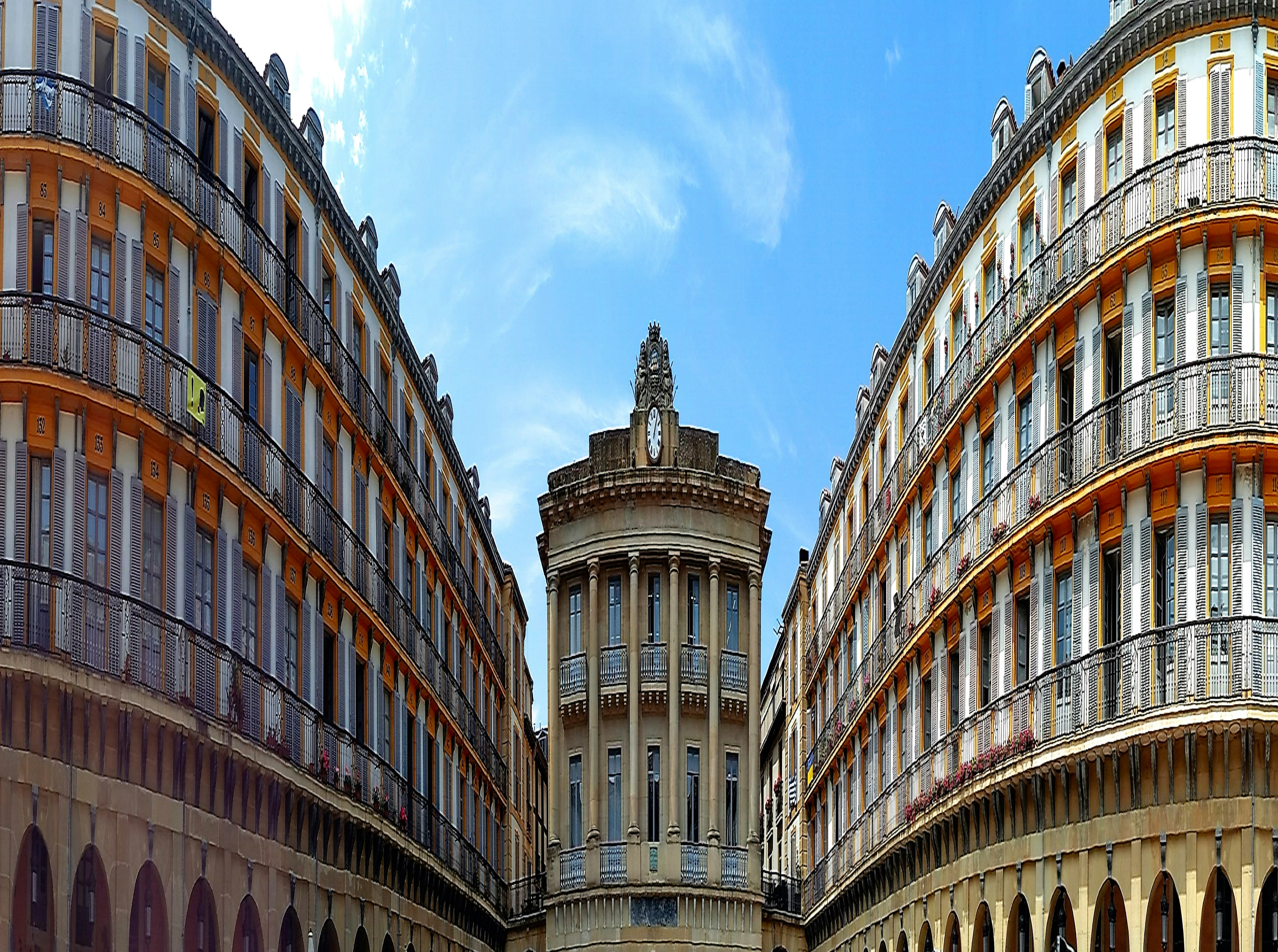 Ornate classical architecture with a central tower under blue sky