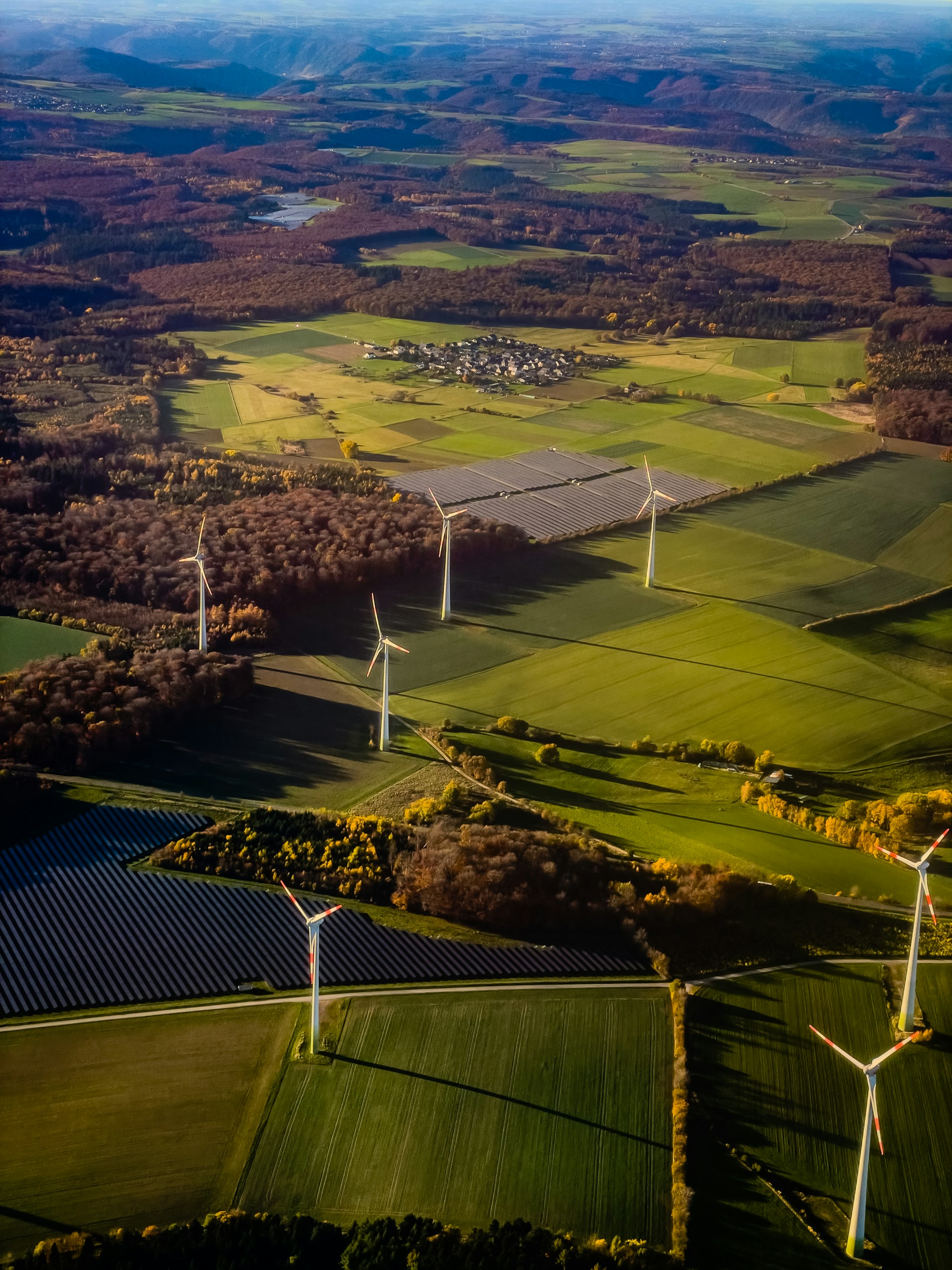 Wind turbines and solar panels in a rural landscape.