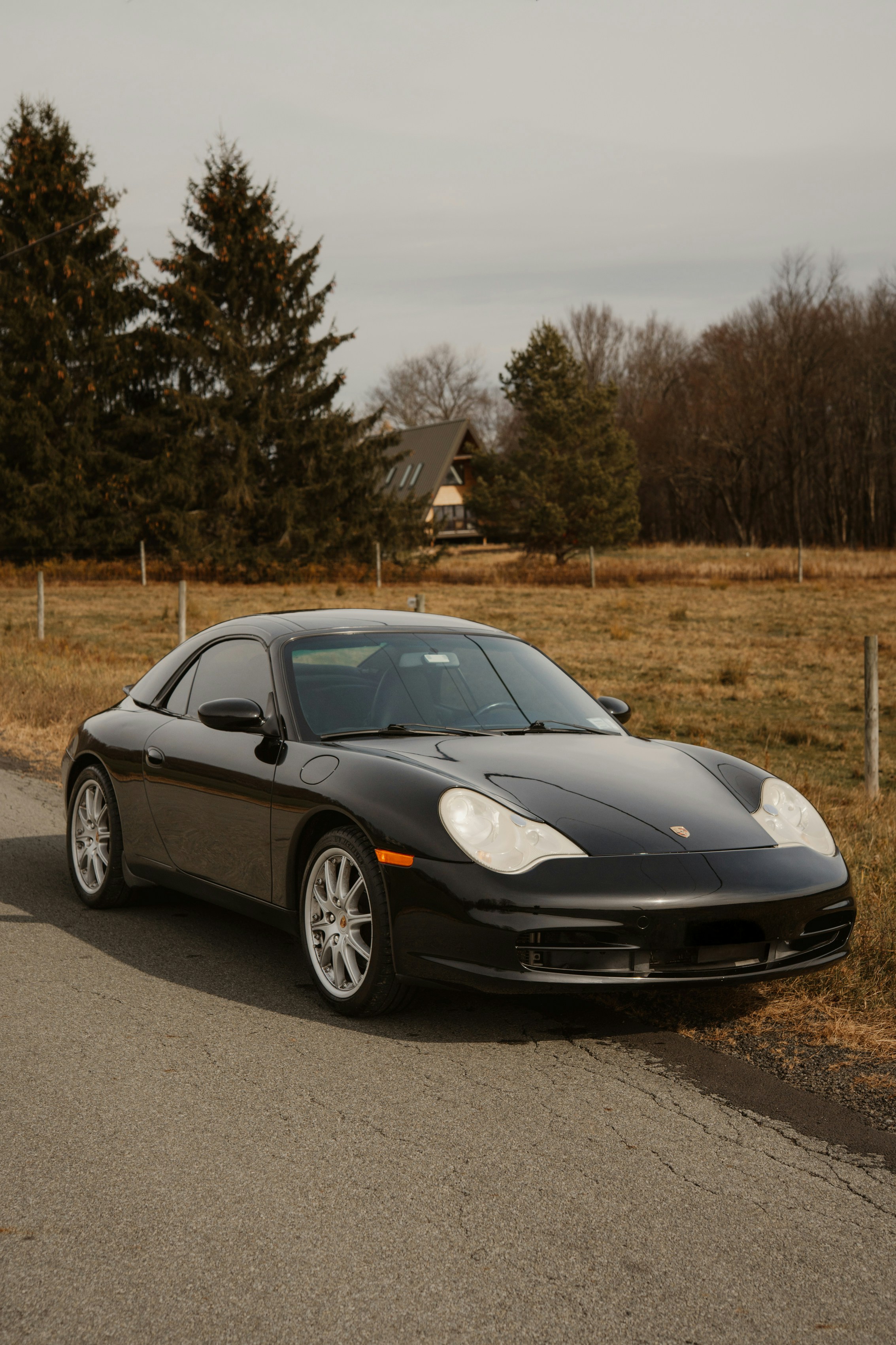 Black porsche parked on a rural road