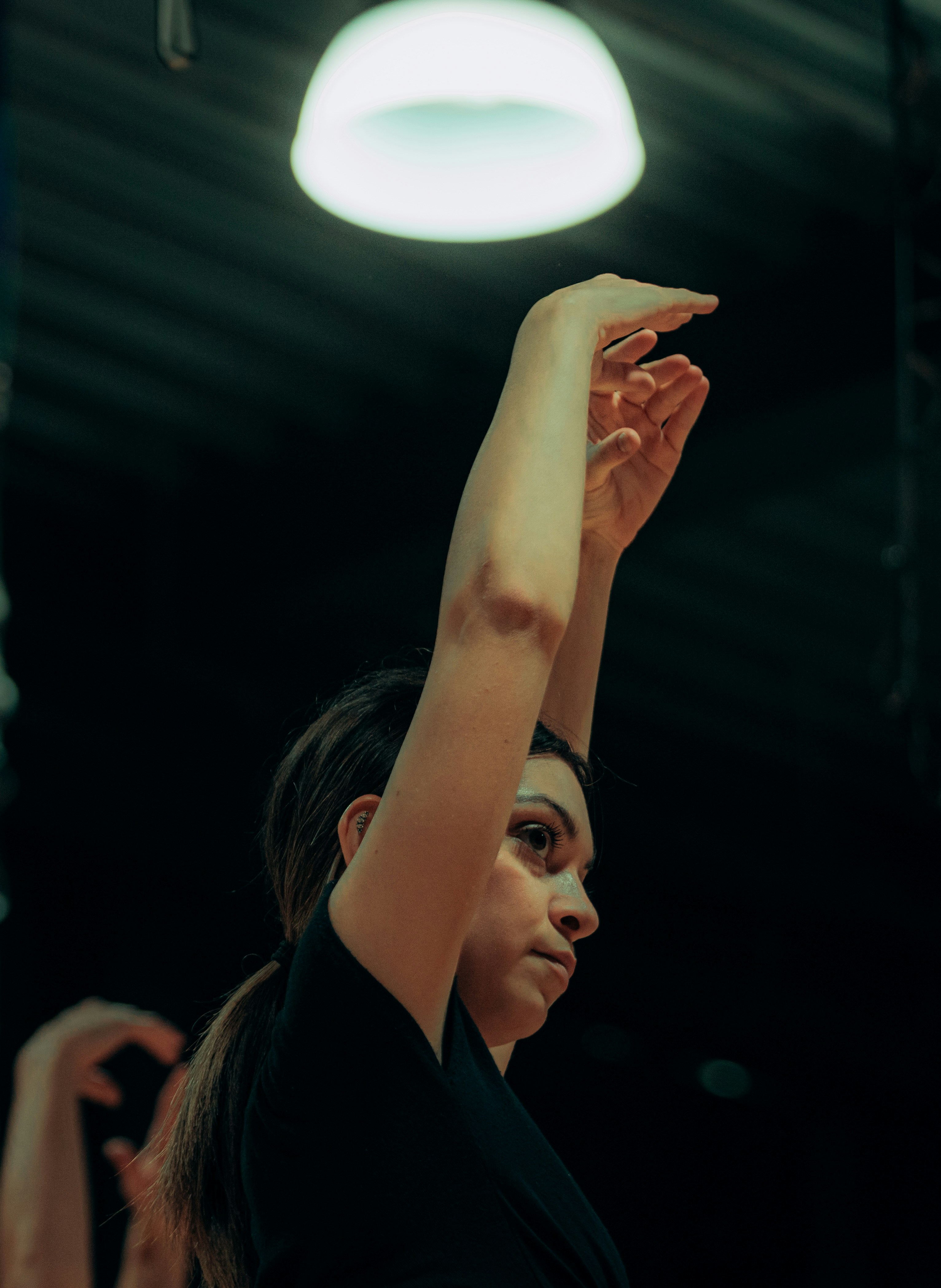 A woman in a black shirt with arms raised