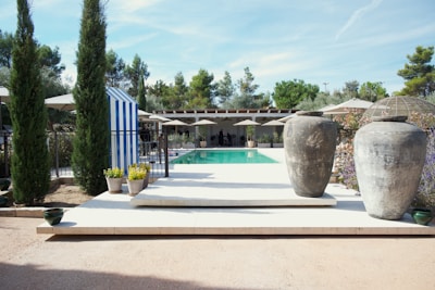 Two large urns flank a swimming pool area