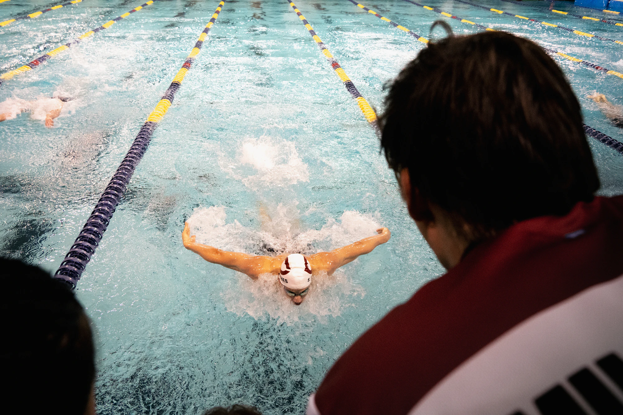 A competitive swimmer performing the butterfly stroke in a pool