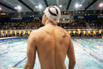 Swimmer with cupping marks on back at pool
