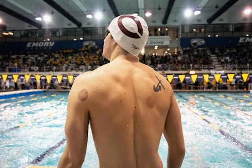 Swimmer with cupping marks on back at pool