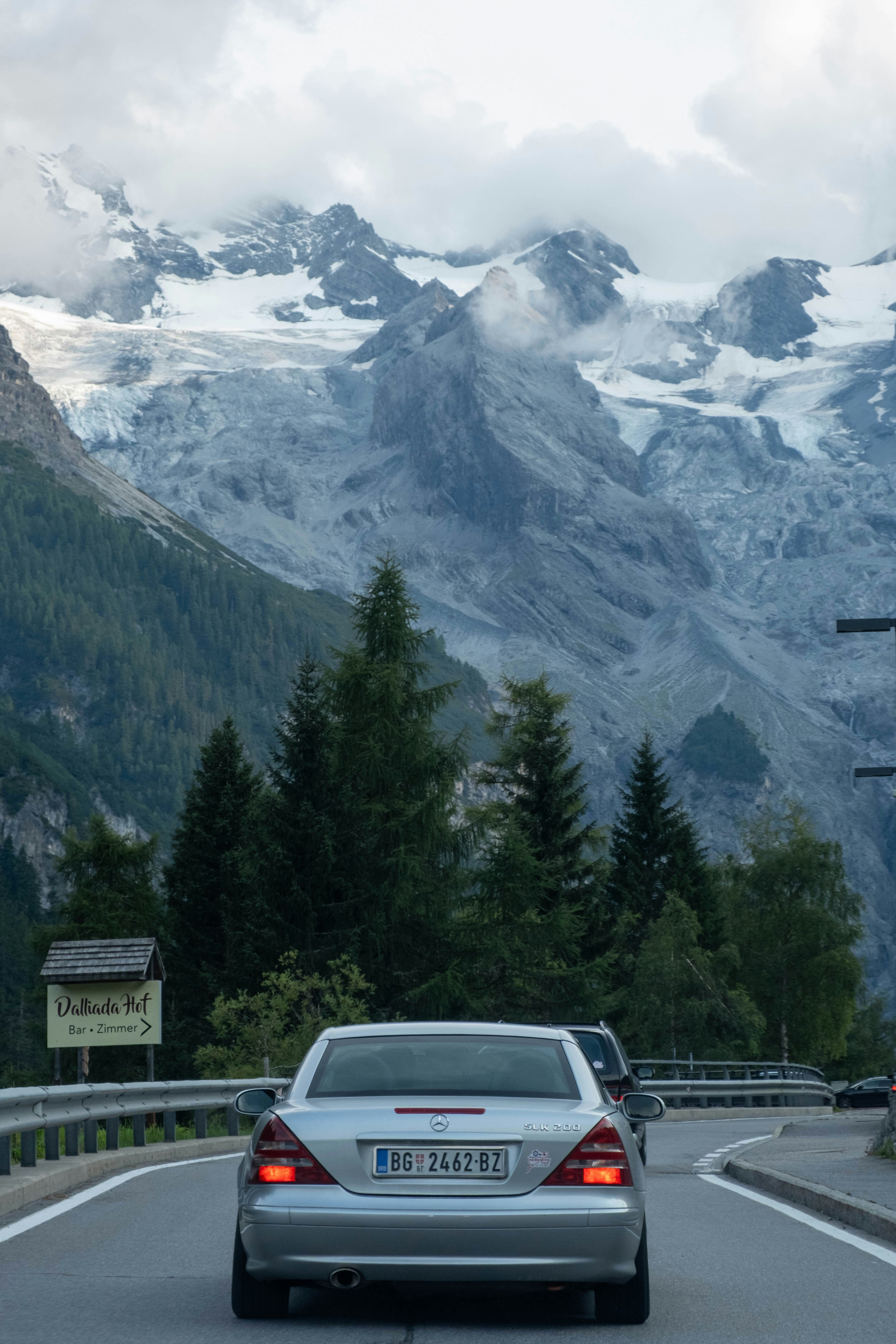 Autos, die auf einer Straße mit verschneiten Bergen fahren.