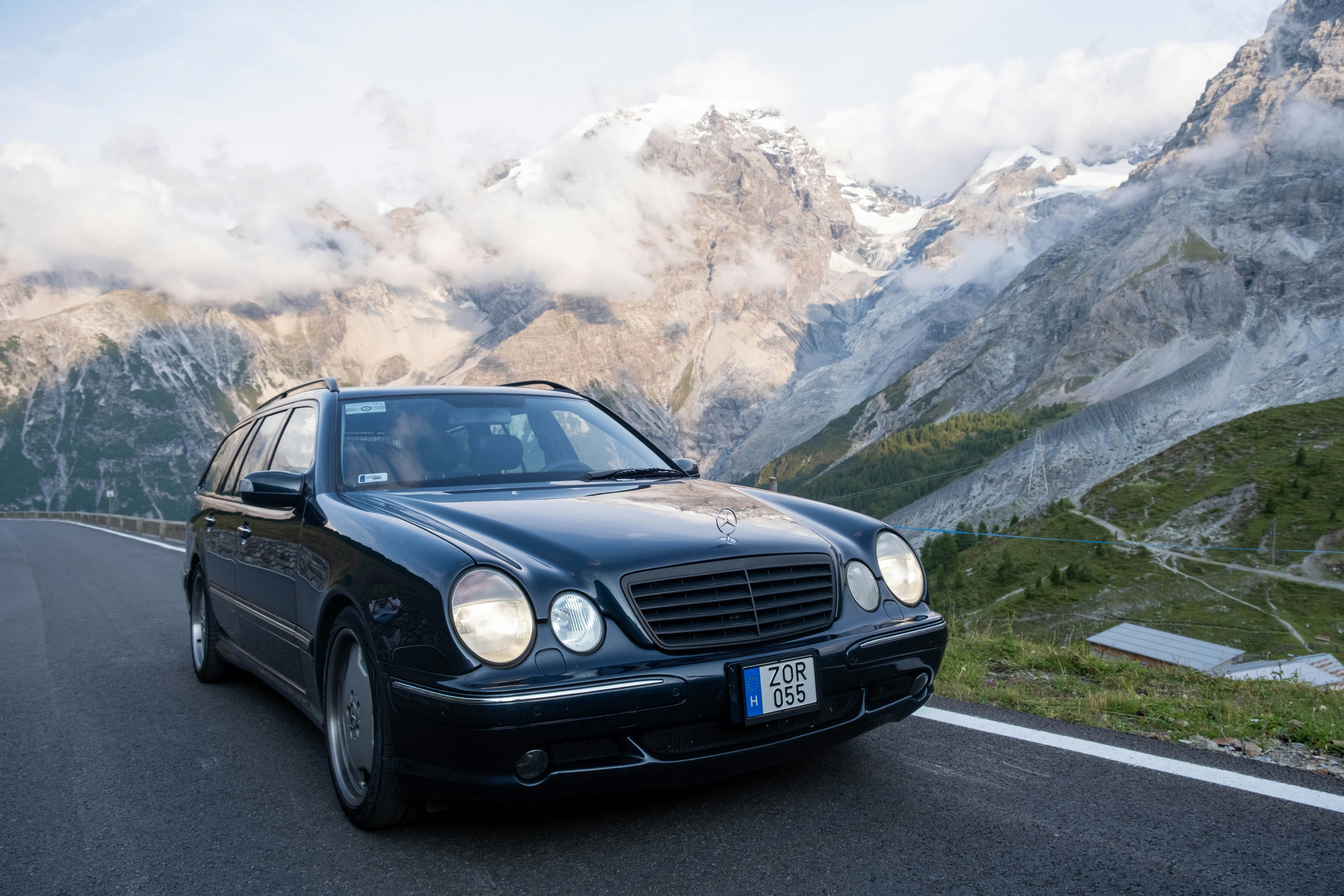 Schwarzes Auto fährt auf einer Bergstraße