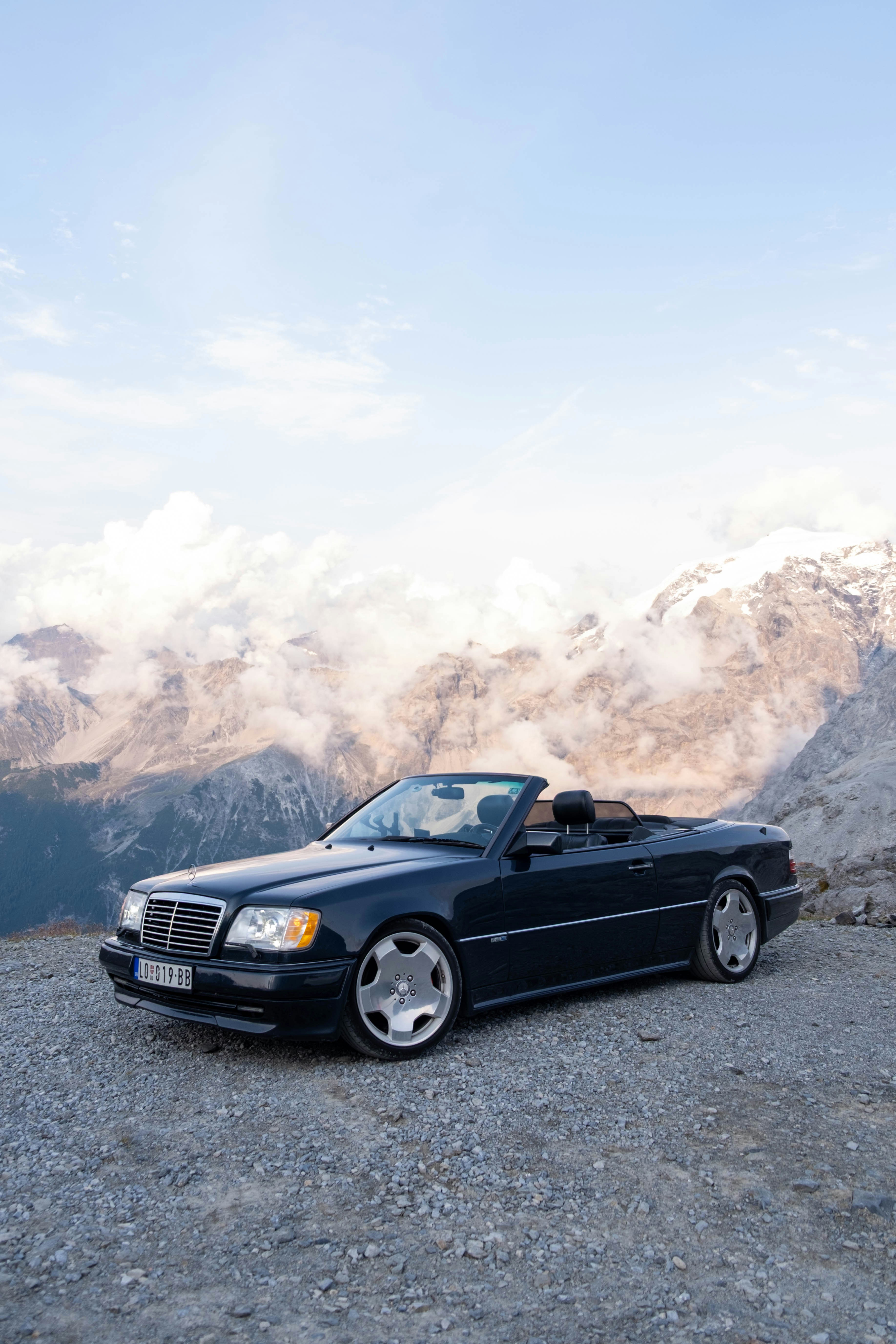 Schwarzes Cabriolet, das an einer Bergstraße geparkt ist.
