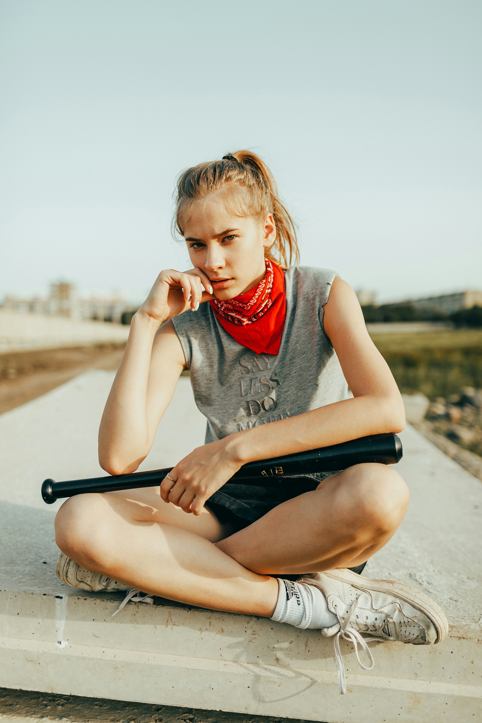 Young woman with baseball bat and red bandana