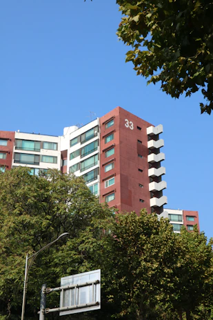 Modern apartment building with red and white facade.