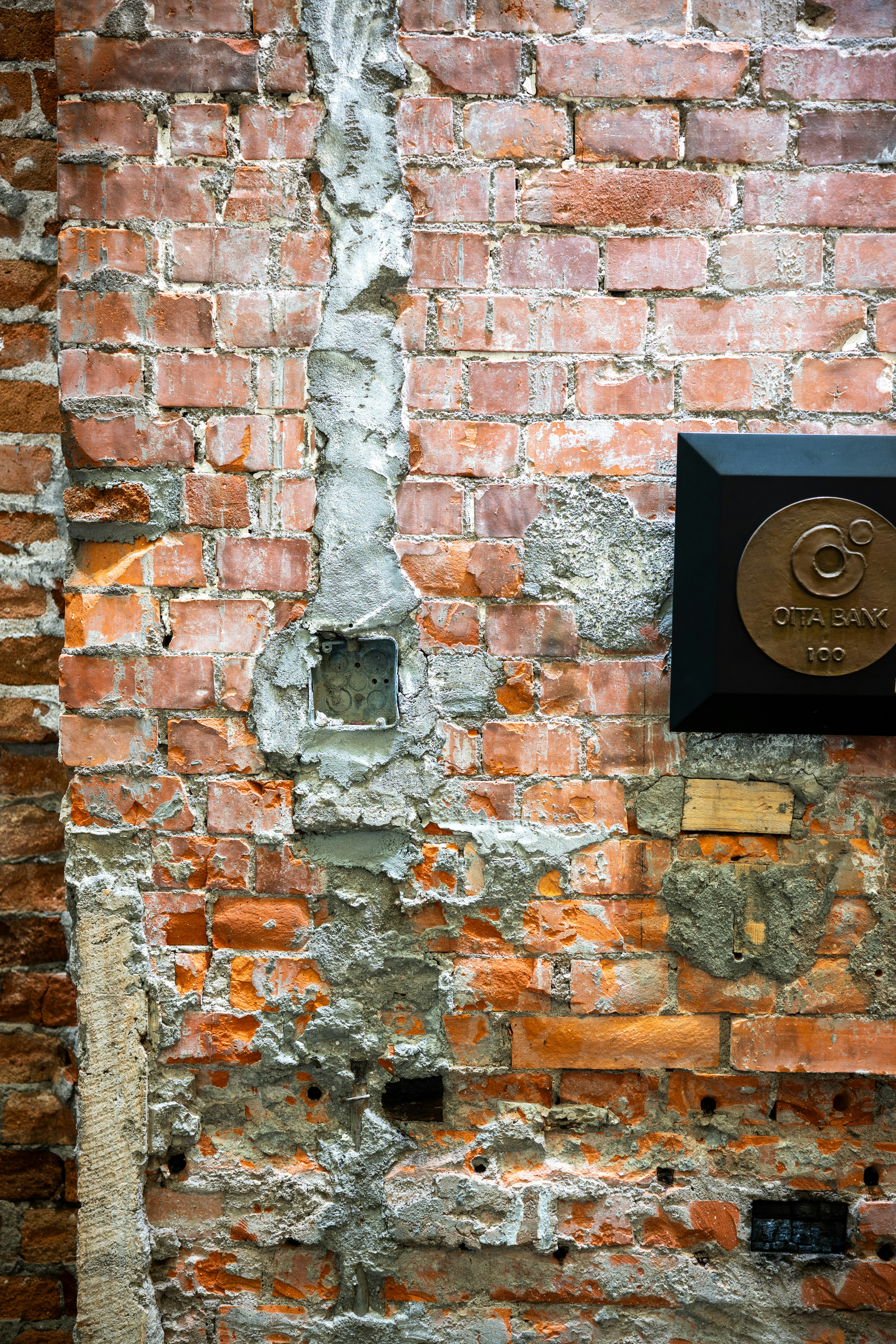 Uma parede de tijolos desgastada com uma placa.