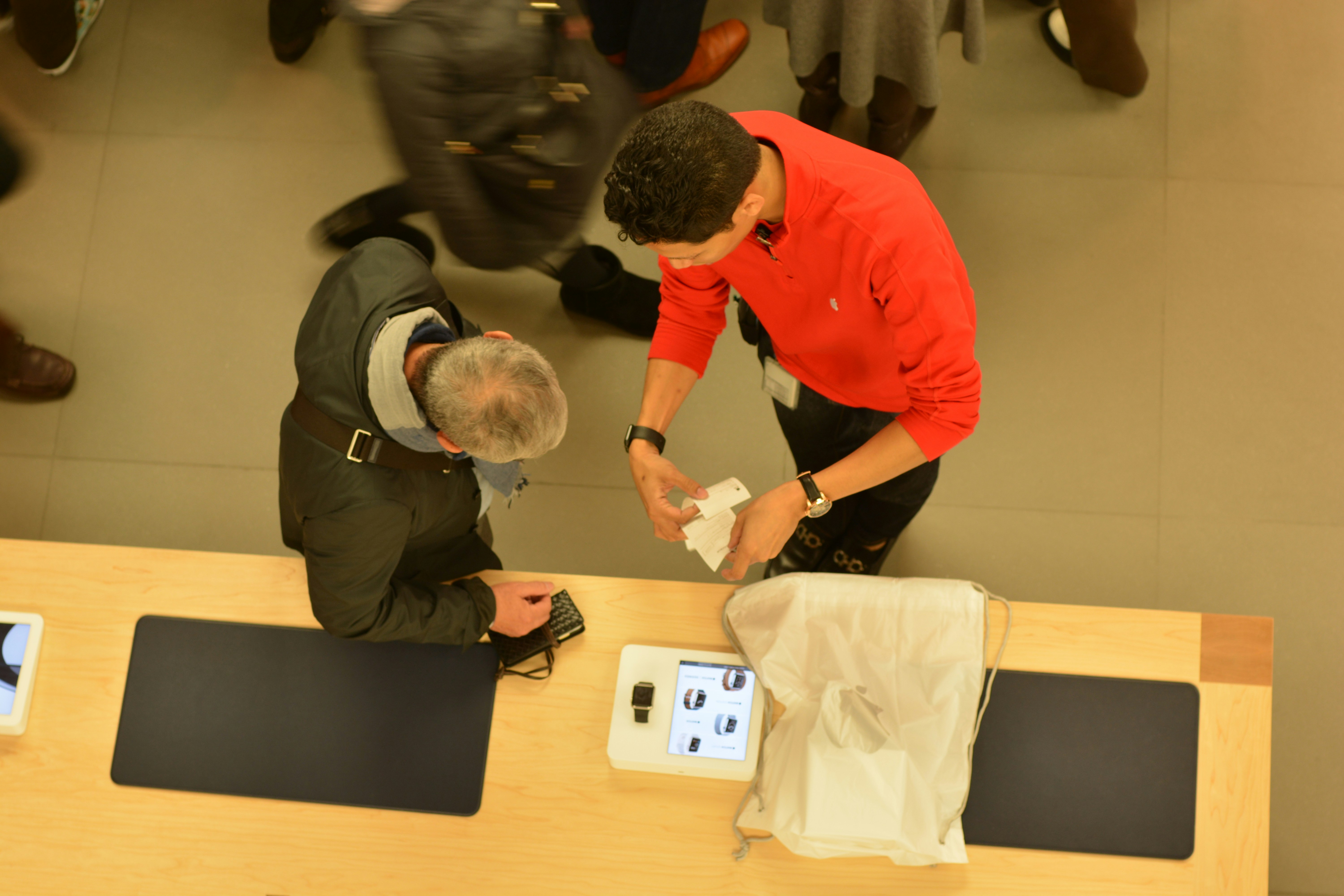 A employee helps a customer at a counter.