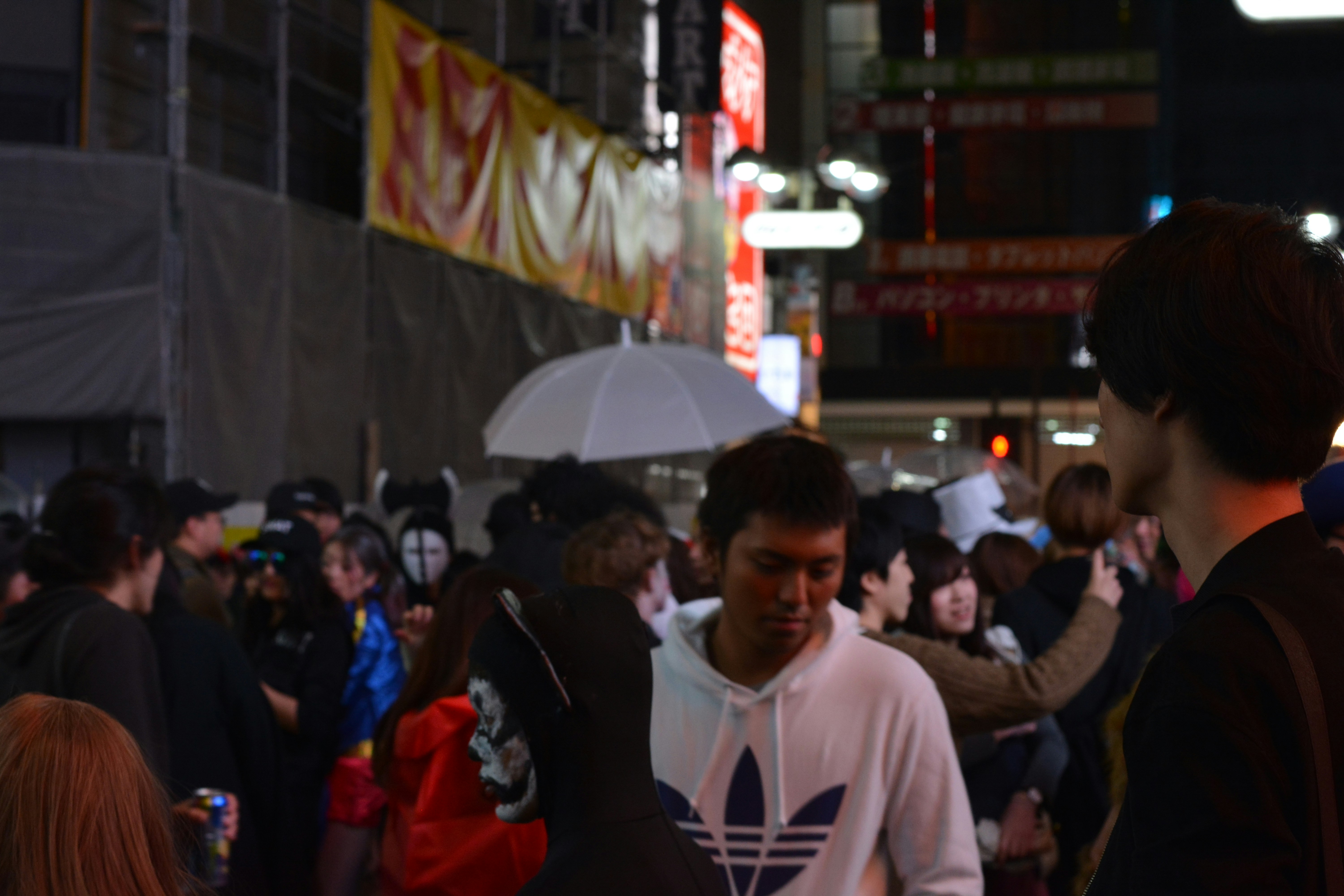 People walking on a busy city street at night.