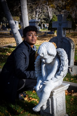 Woman with angel statue in cemetery
