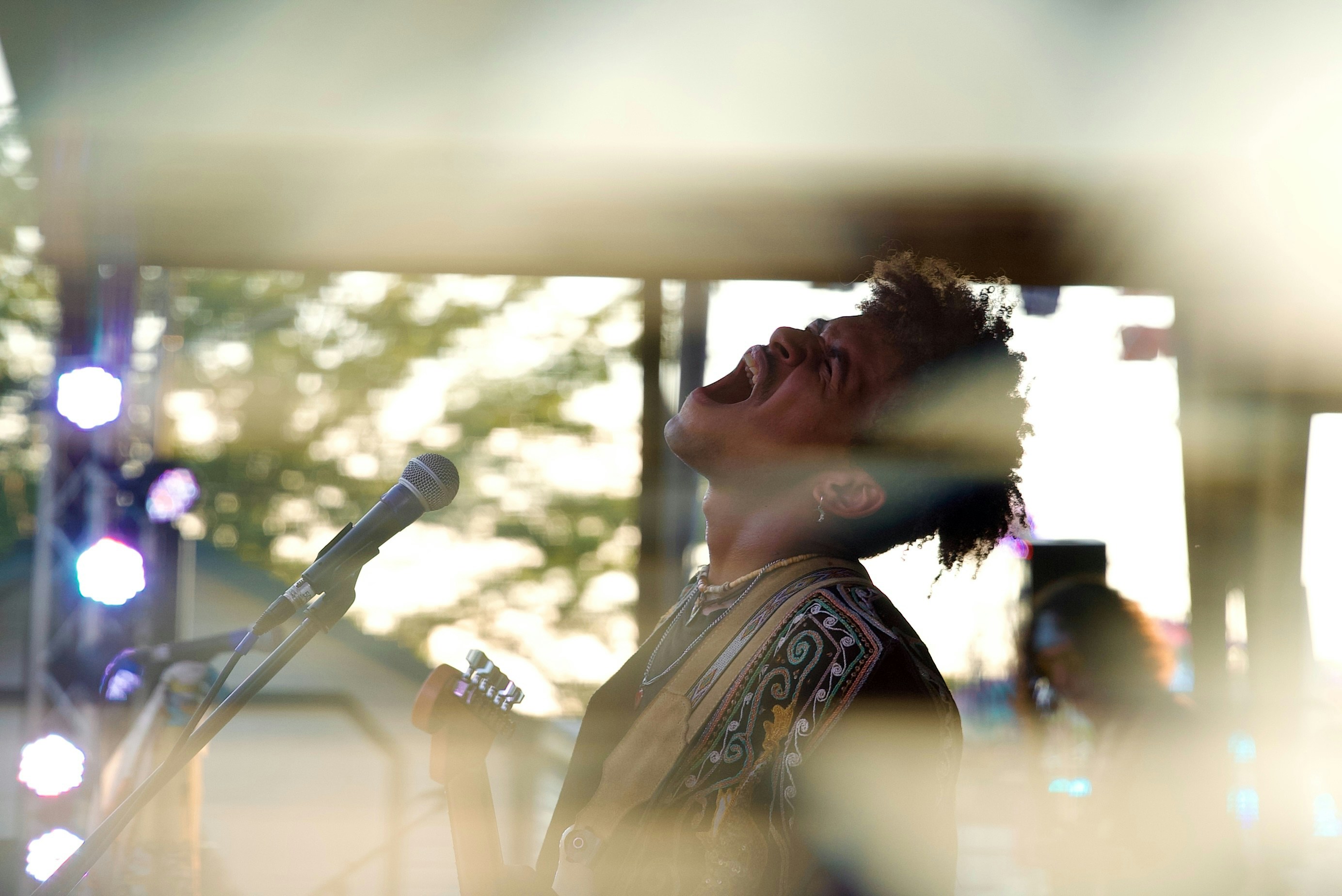 A singer passionately performs on stage with microphone.