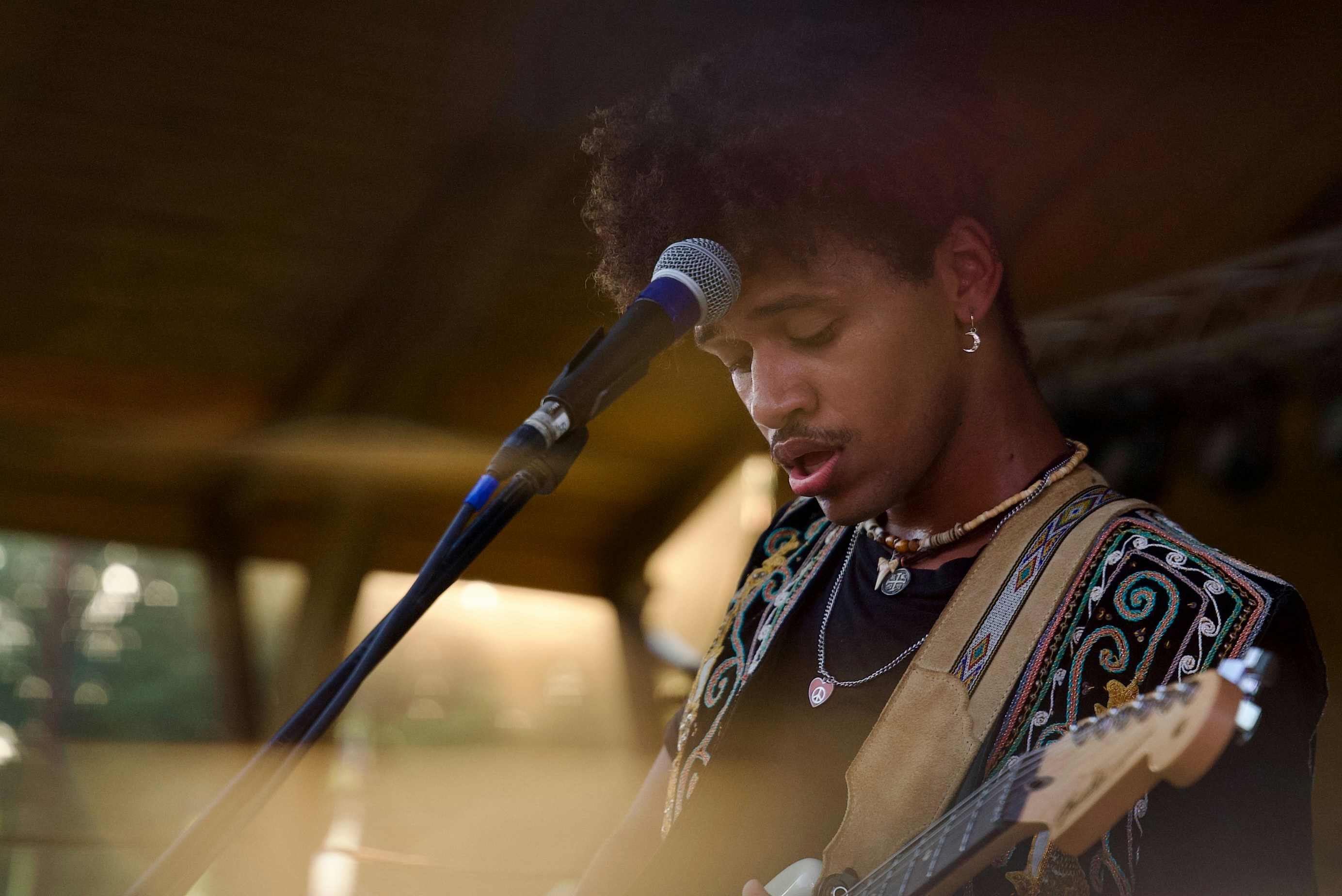 Young man playing guitar and singing into microphone
