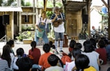 Performers entertain children with music and laughter.