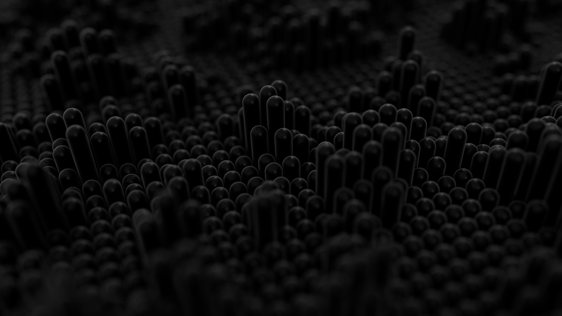 Dark textured surface with raised cylindrical shapes.