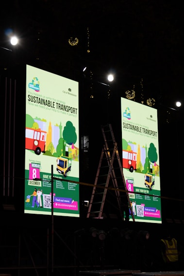 Two large screens displaying sustainable transport event information