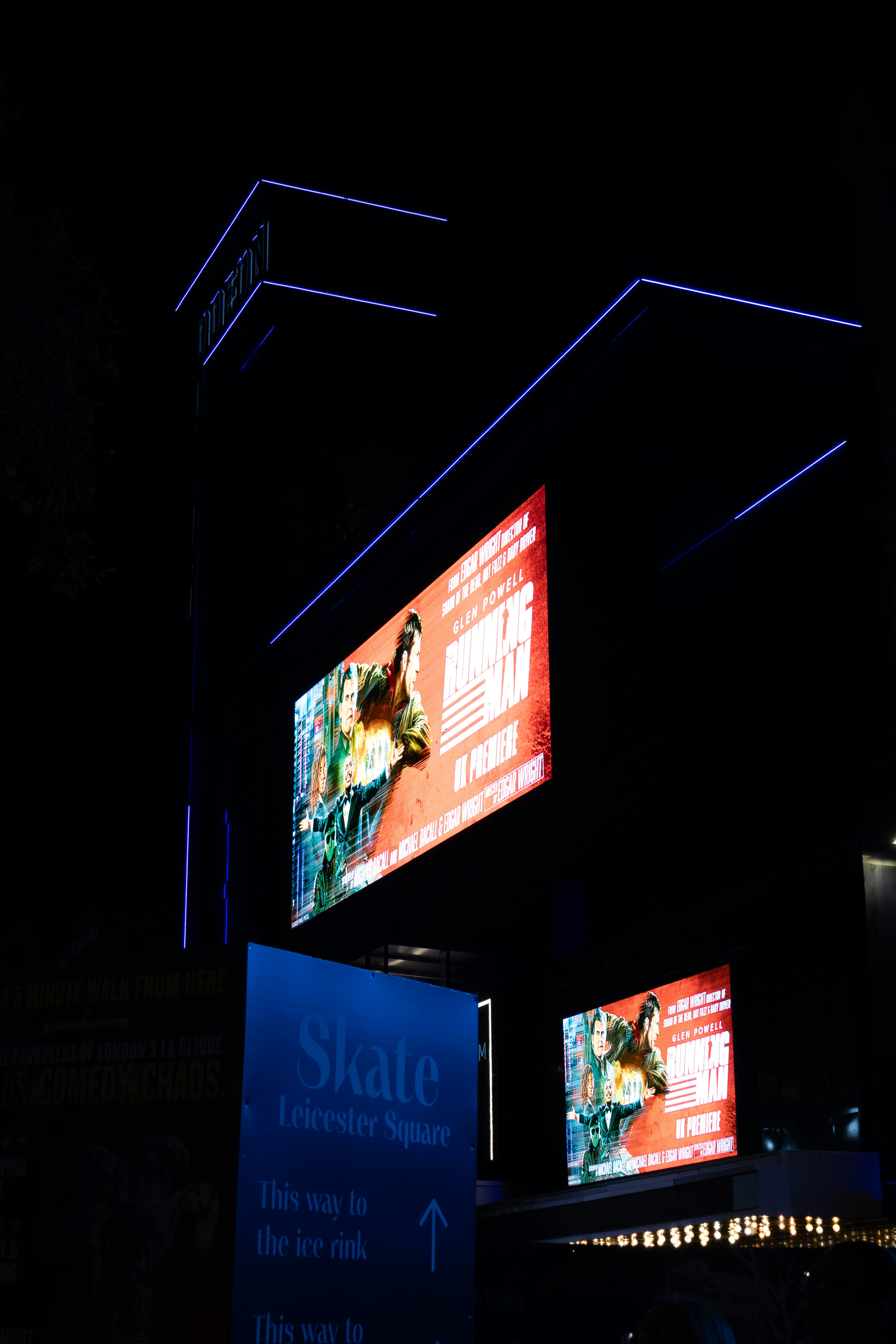 Paisaje urbano nocturno con vallas publicitarias y letreros iluminados