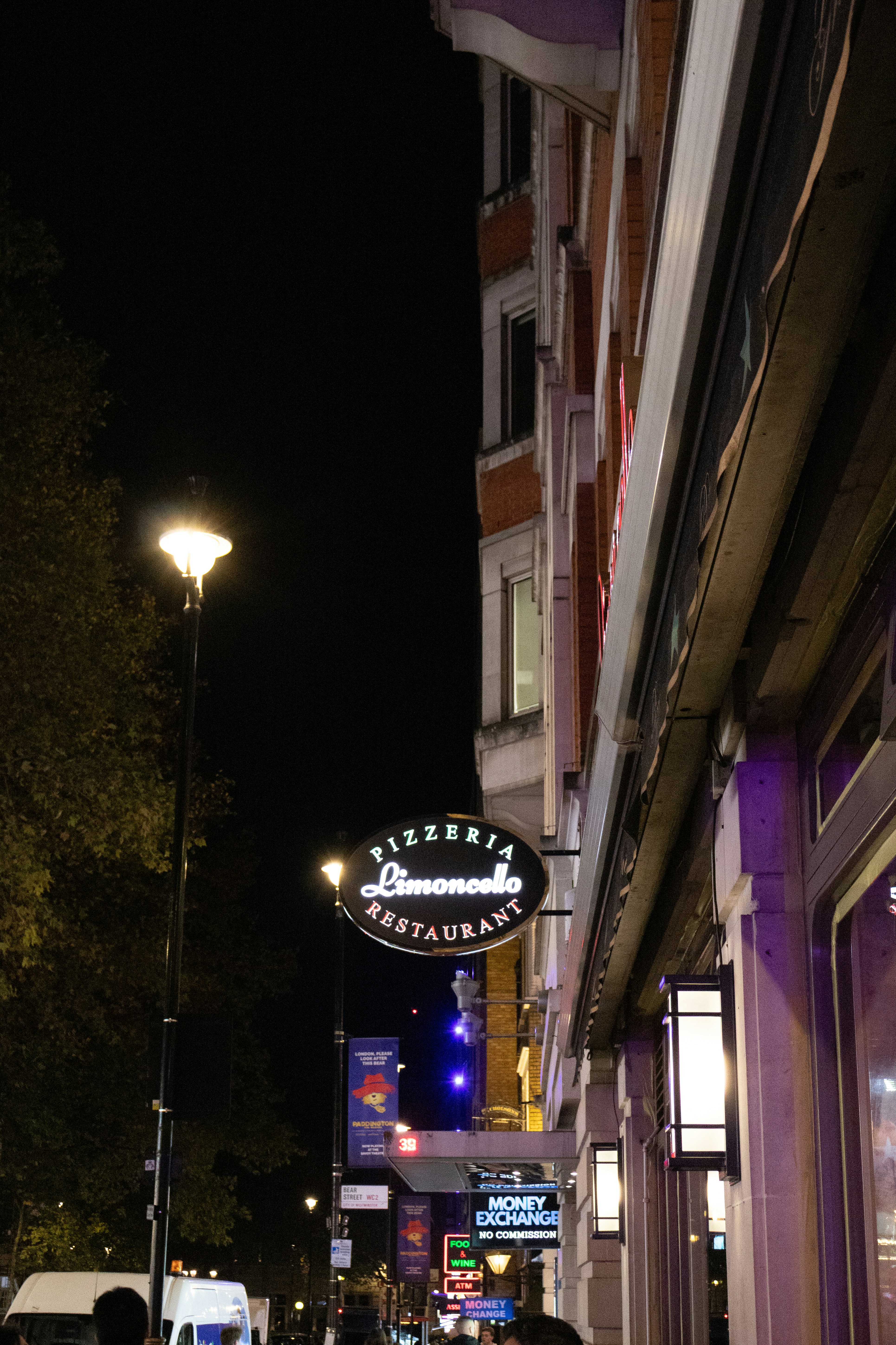 Pizzeria restaurant sign at night on city street