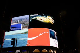 Bright billboards illuminate a city at night.