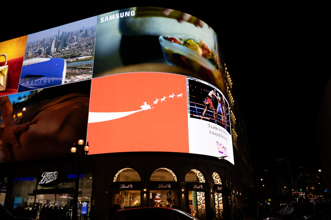 Bright digital billboards illuminating a city street at night