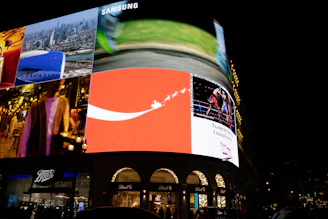 Bright billboards illuminate a city street at night.