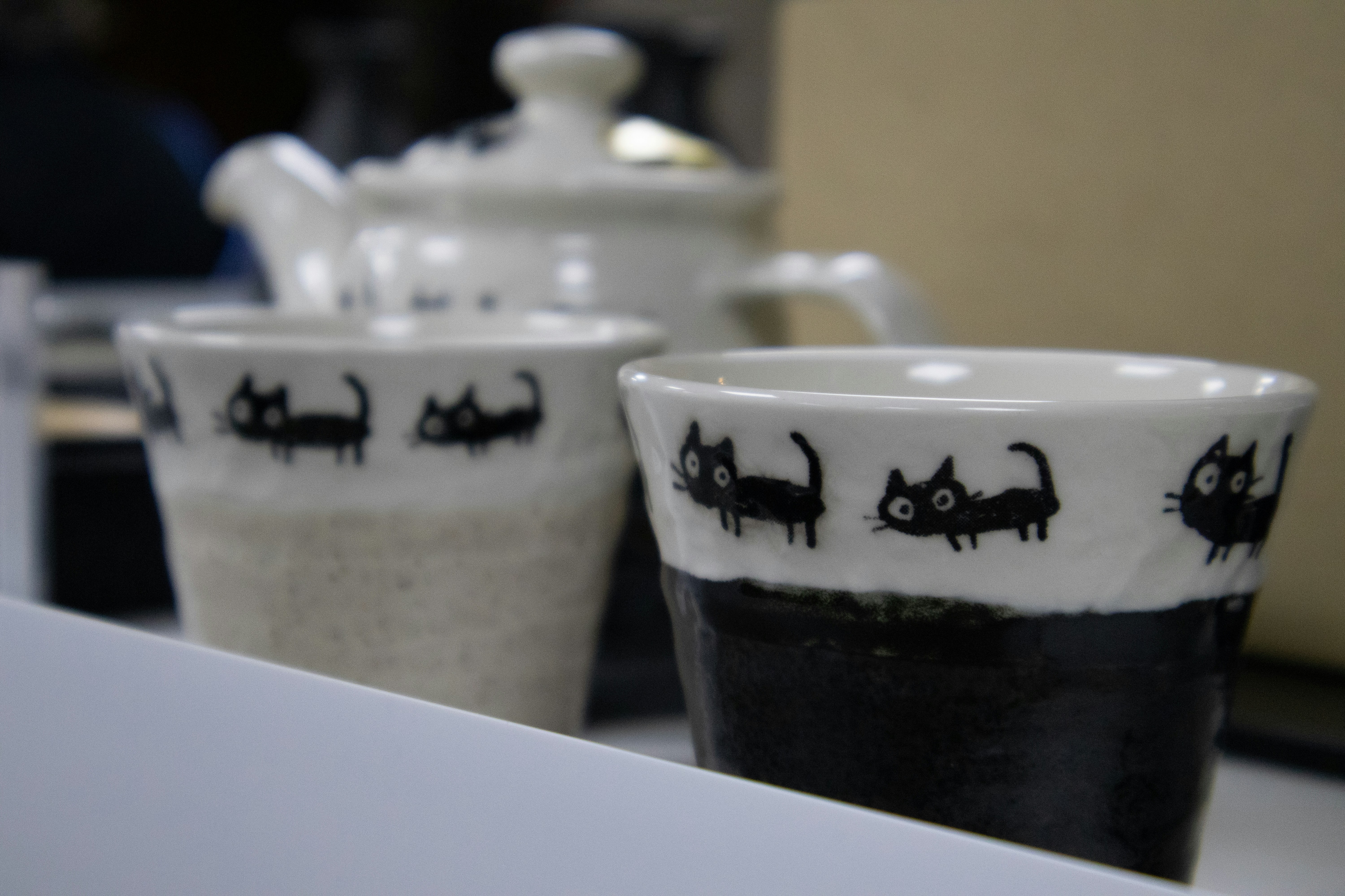Two ceramic cups with black cat designs