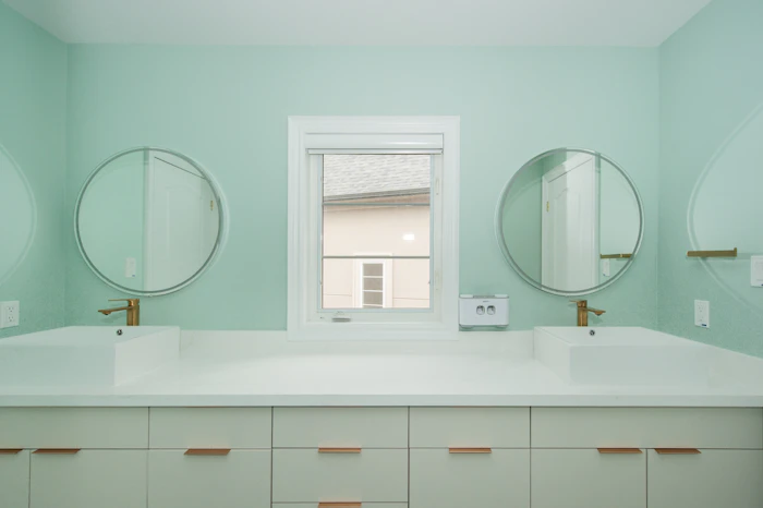 Modern bathroom with a double vanity and mint green walls