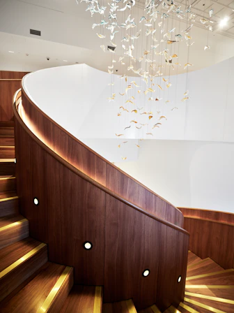 Modern spiral staircase with wooden steps and railing.