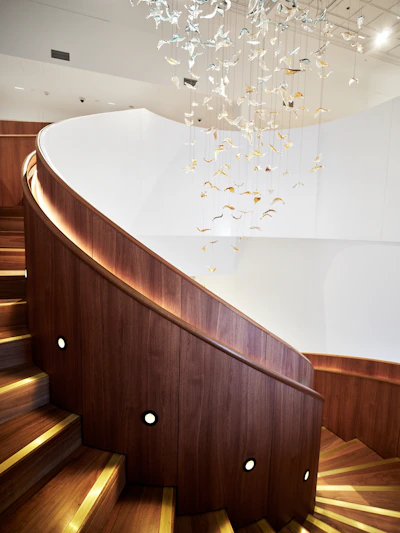 Modern spiral staircase with wooden steps and railing.