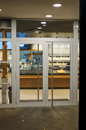 Entrance to a brightly lit bakery with glass doors