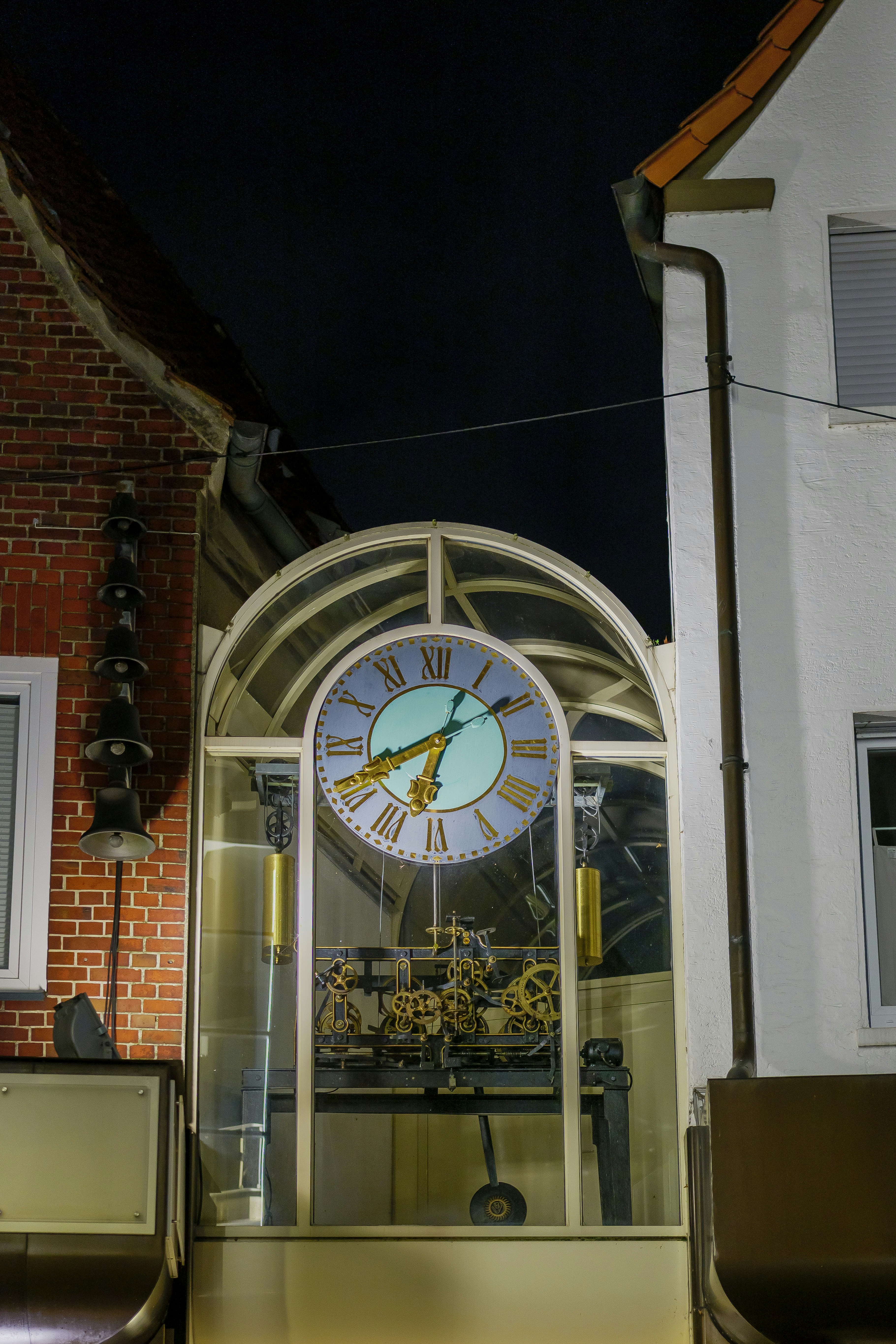 Grande torre do relógio com engrenagens visíveis à noite