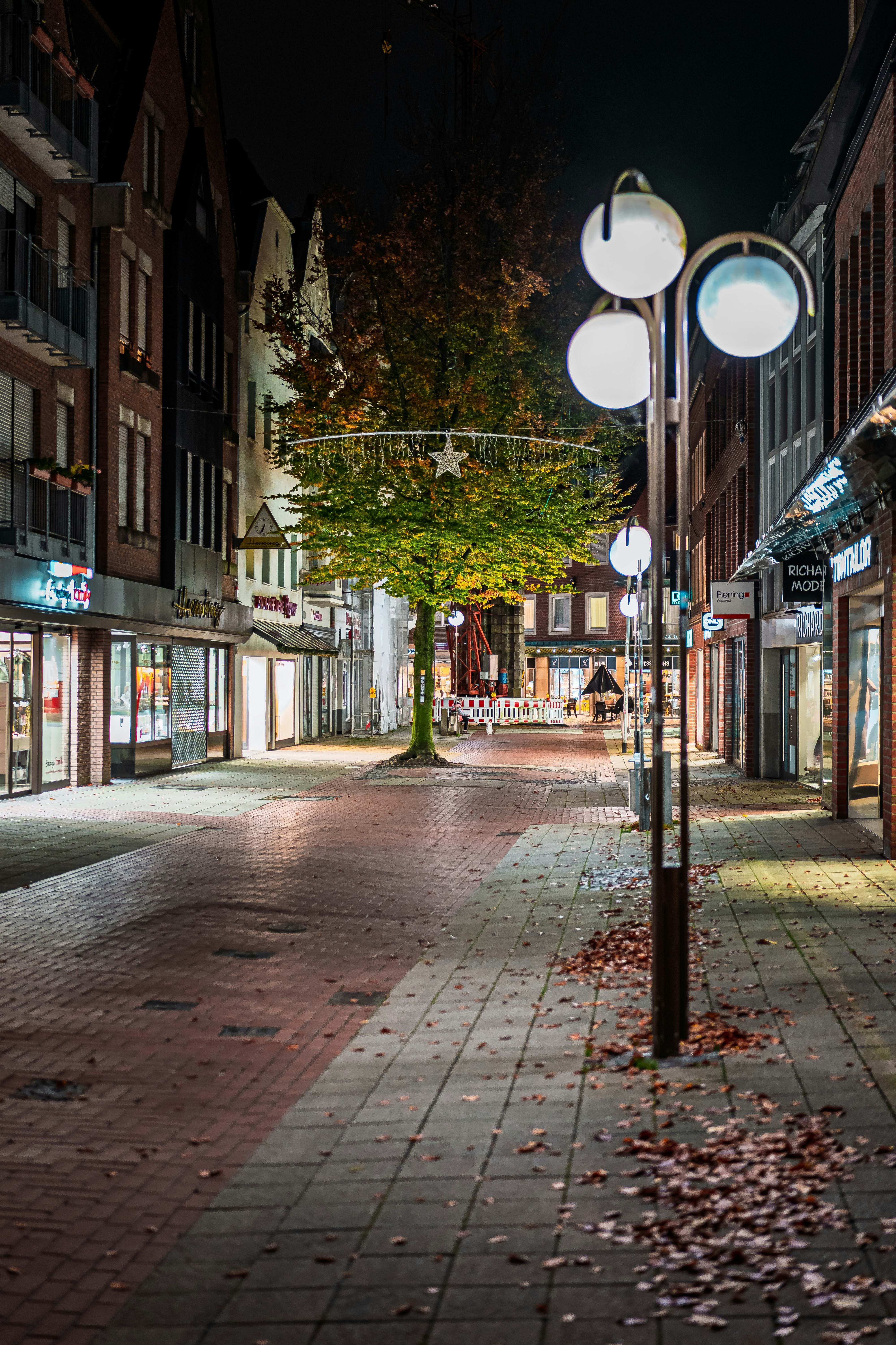 Empty street lined with shops at night